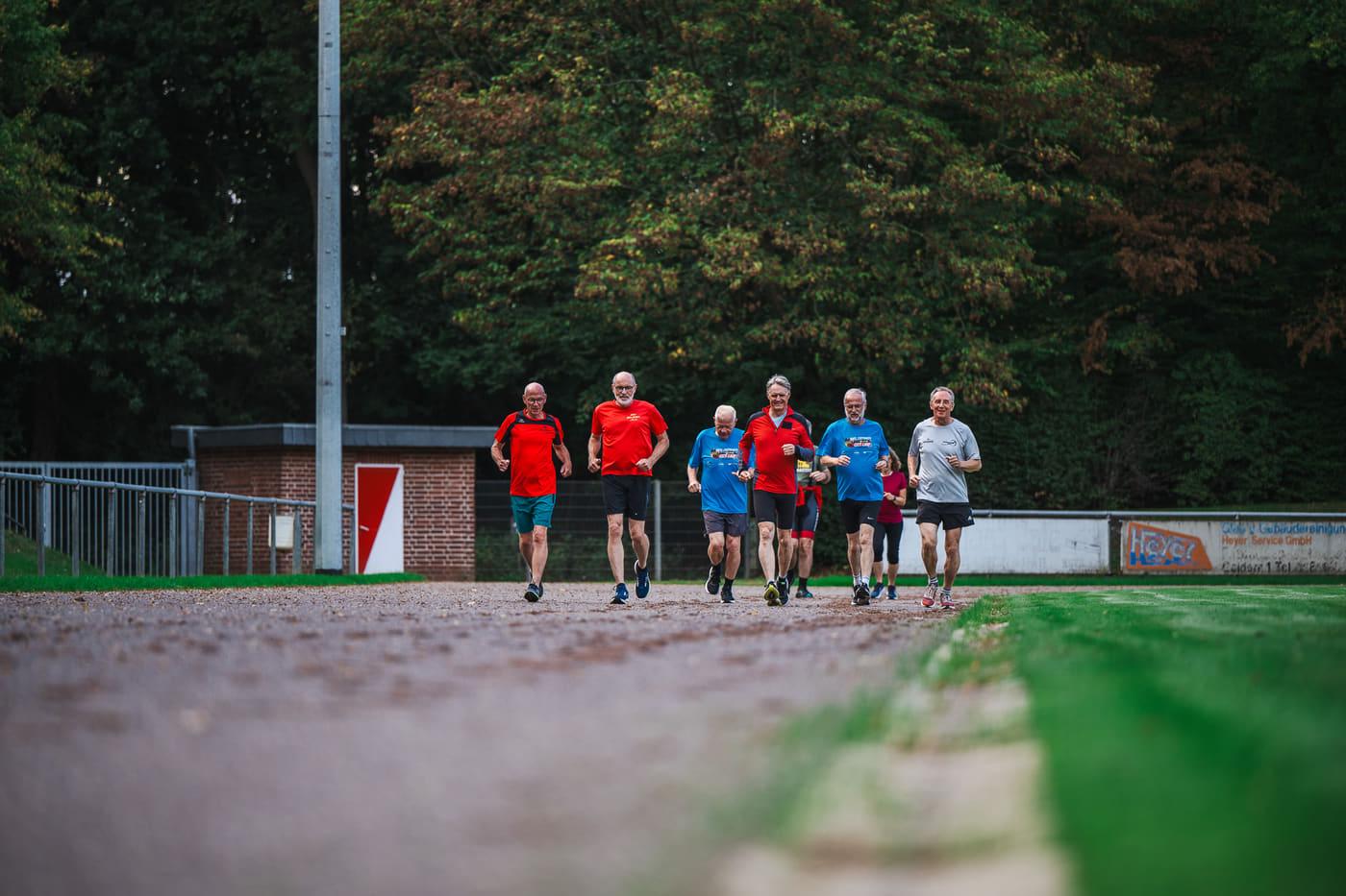 Die Laufgruppe biegt vor der Tribüne des Gelderlandstadions auf den Rundweg ein