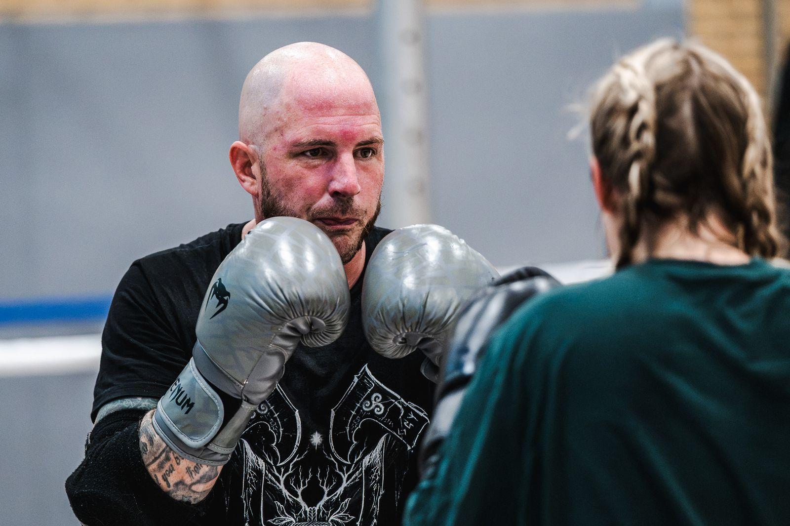 Zwei Sportler im Clinch mit silbernen Boxhandschuhen