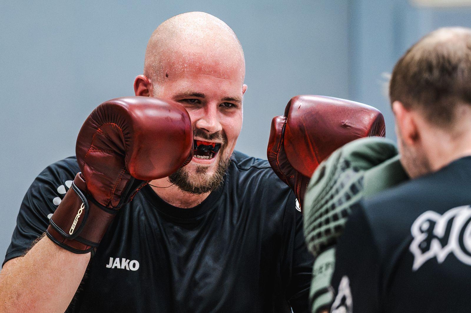 Sportler mit roten Boxhandschuhen lacht in die Kamera
