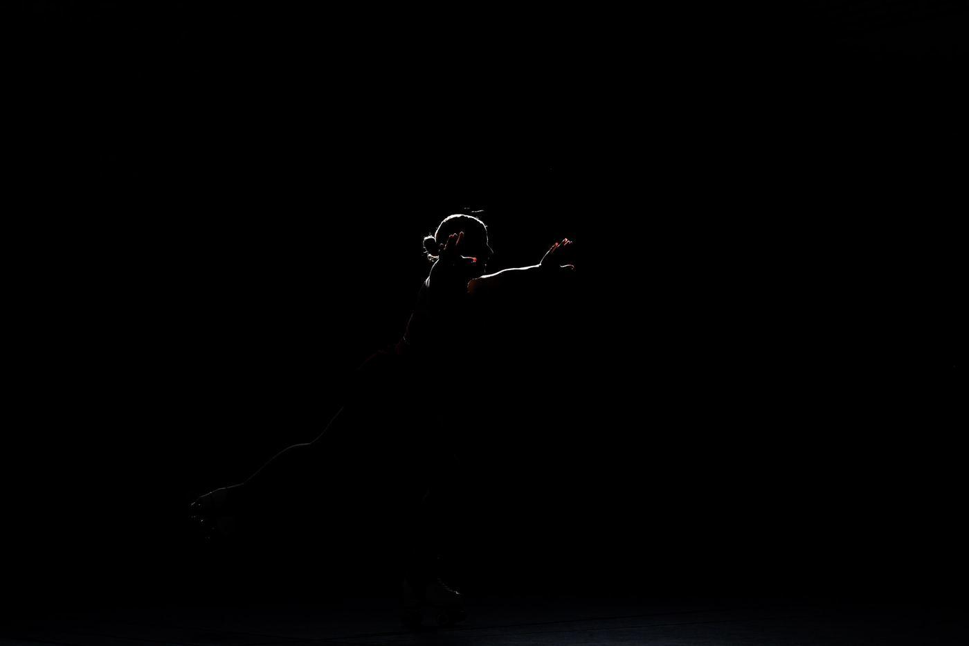 Silhouette einer Läuferin vor dunklem Hintergrund