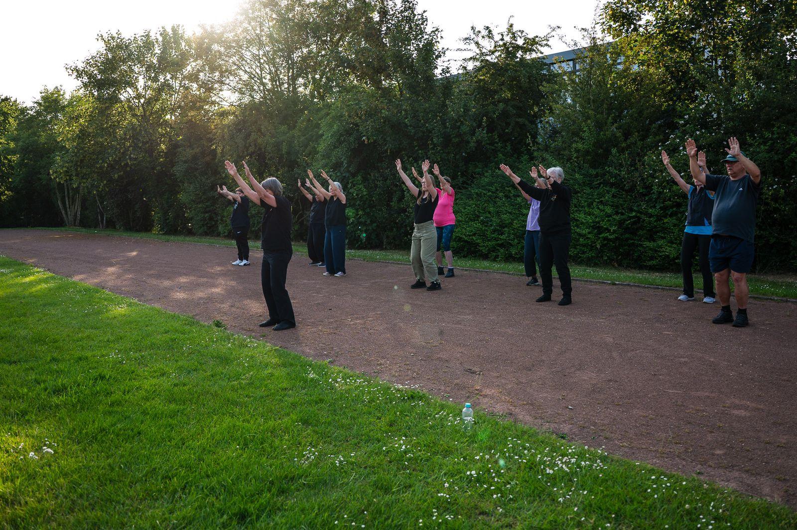 Die Gruppe hebt bei Sonnenuntergang gemeinsam die Arme
