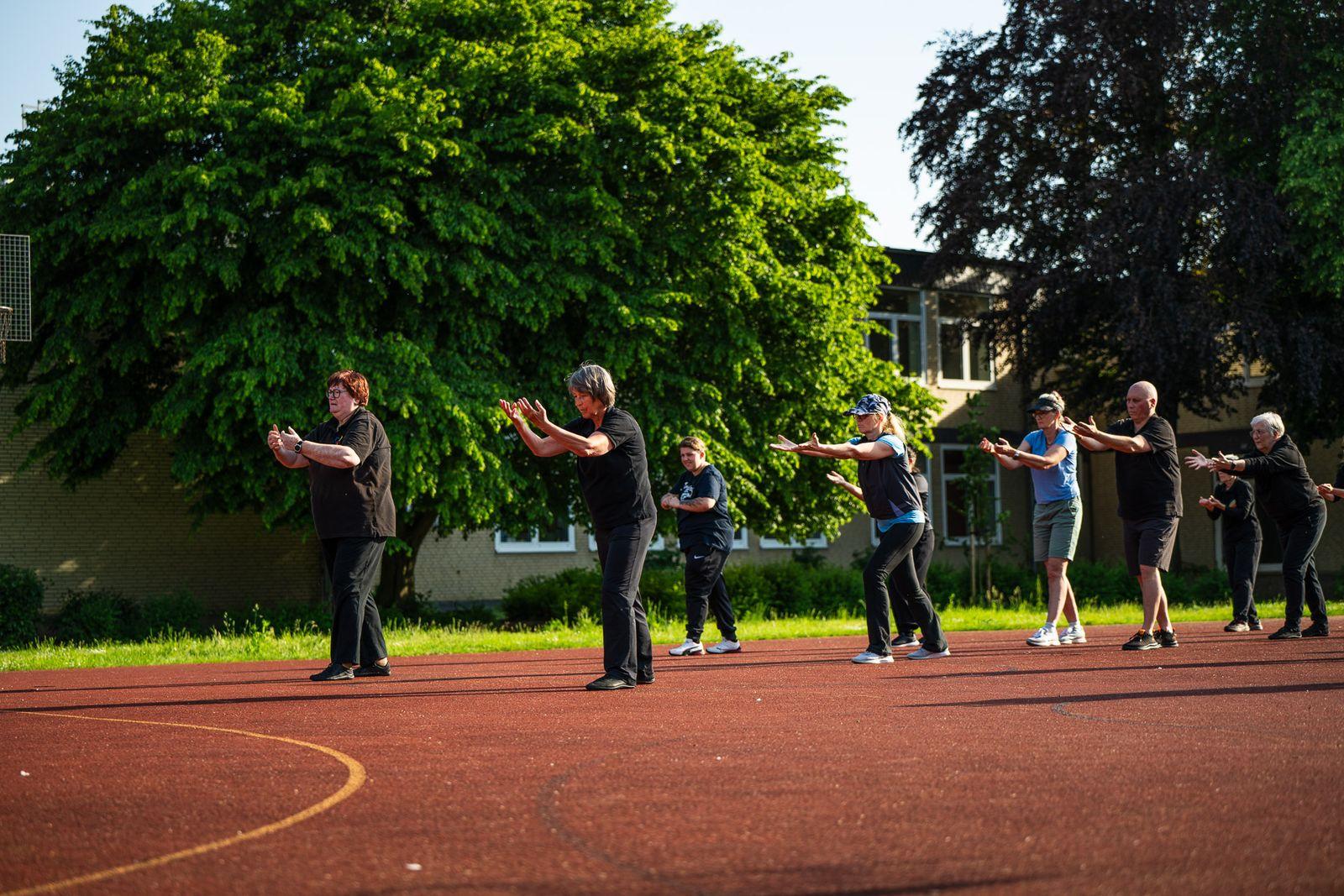 Die Gruppe übt im Abendlicht auf dem Sportplatz