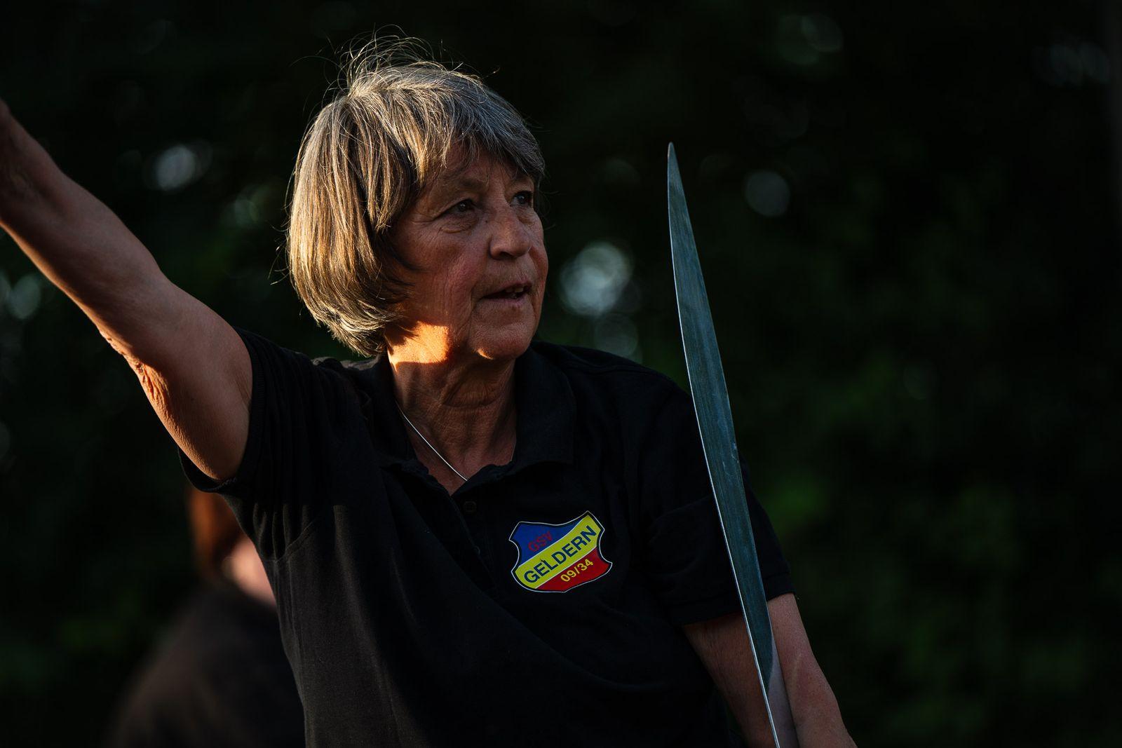 Übende führt eine Form mit dem Tai-Chi-Schwert aus